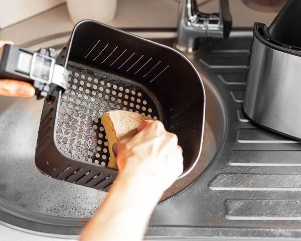 Trước tiên vệ sinh nồi chiên không dầu mới mua, hãy tháo khay và giỏ chiên ra khỏi nồi rồi rửa nhẹ bằng nước ấm và một chút nước rửa chén