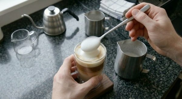 Cà phê Capuchino là gì? Cách pha cà phê Capuchino chuẩn vị. 7 Dùng thìa múc lớp bọt sữa xốp mịn phủ lên trên cùng để hoàn thiện ly Capuchino phân tầng đẹp mắt.