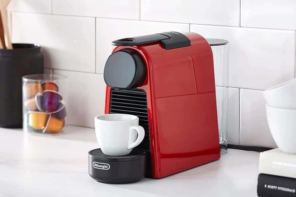 Hướng dẫn sử dụng máy pha cà phê viên nén từ A–Z: pha, vệ sinh, mẹo | Minhaus 1 Máy pha cà phê viên nén với viên capsule và ly espresso trên quầy bếp